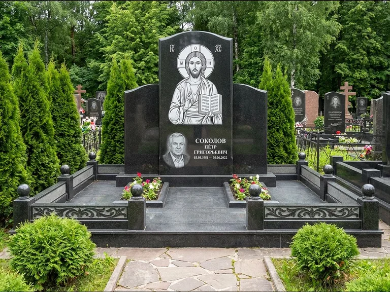 Памятник с гравировкой иконы: широкая горизонтальная лежачая плита-стела — икона в резной рамке-киоте, серая гравийная отсыпка с бордюром, работа «Богданова» в Сочи