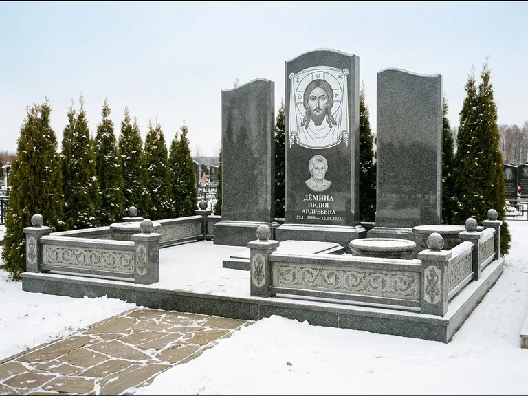 Памятник с гравировкой иконы: узкая вертикальная стела-пилон с ликом — икона в резной рамке-киоте, открытая лужайка без ограды, работа «Одинцов» в Сочи