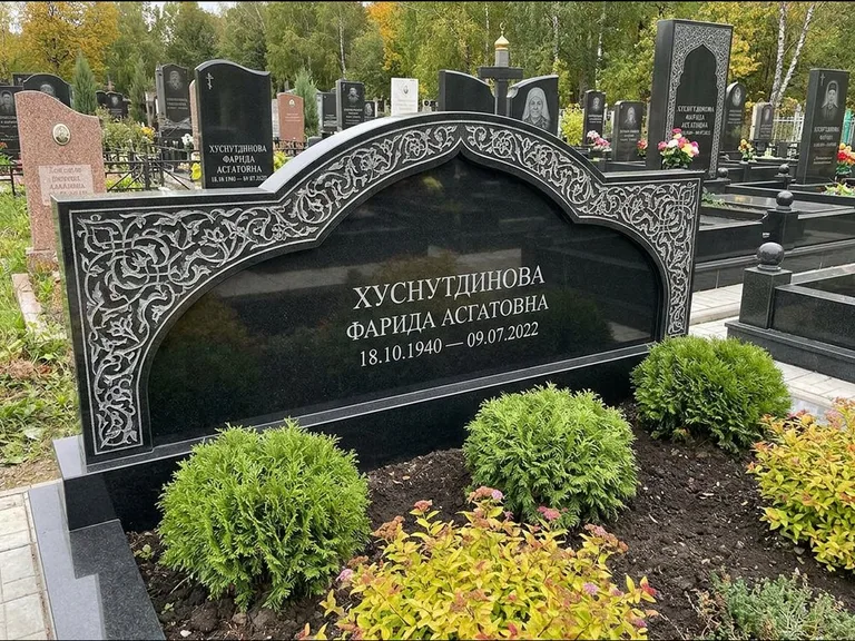 Мусульманский памятник: вытянутая горизонтальная семейная стела с аркой — белая гравировка силуэта мечети с минаретами, участок с декоративными кустами, работа «Зарипова» в Сочи