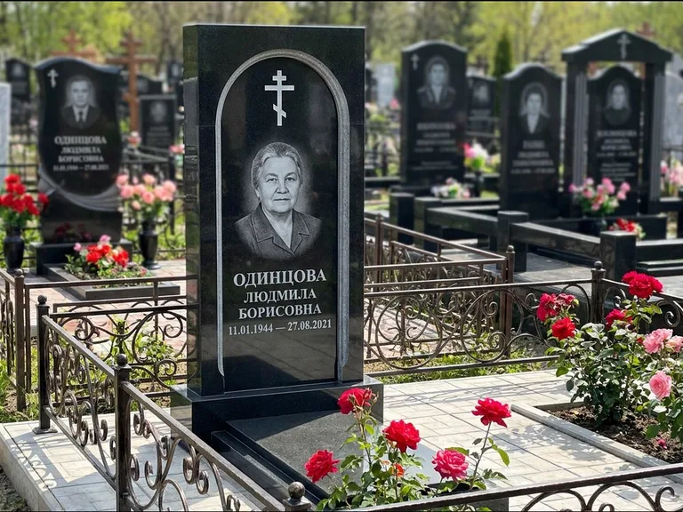 Памятник из чёрного гранита — скромная невысокая стела с крестом с терновым венцом, работа «Лаврентьева» в Сочи