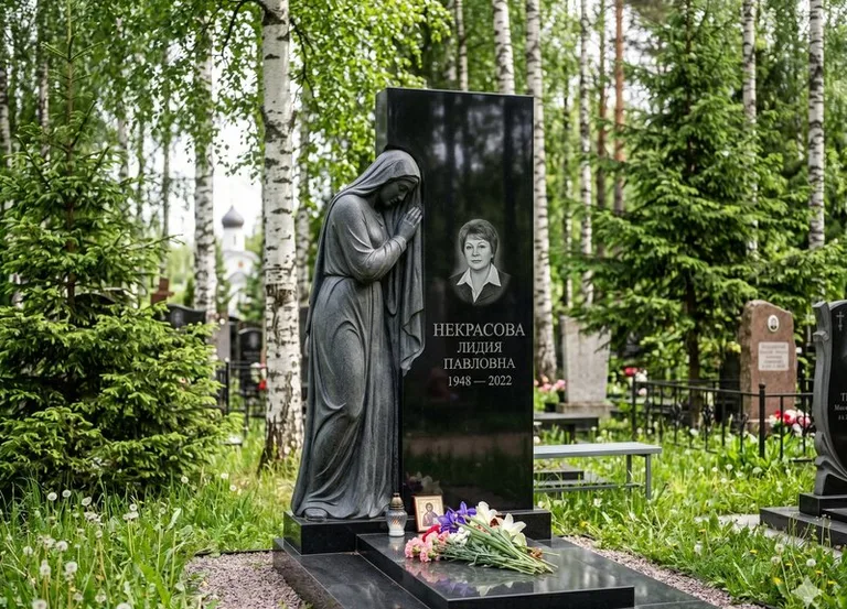 Гранитная фигура скорбящего мужчины у чёрной стелы в Сочи